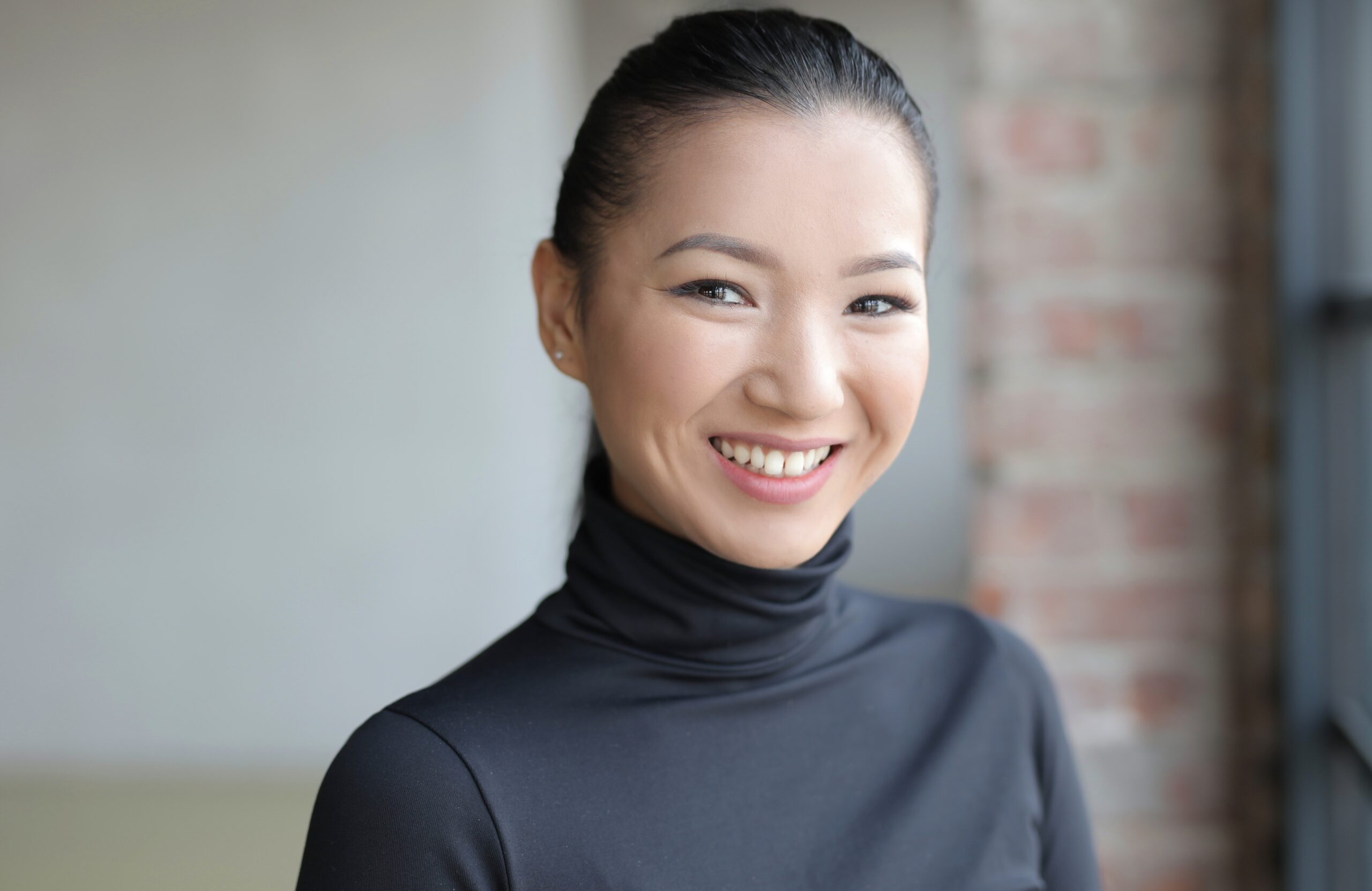attractive asian female in a black outfit smiling gently