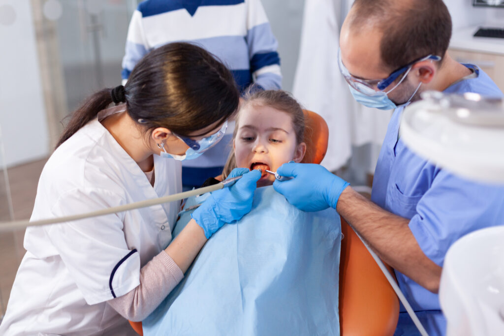 little girl with mouth open in the course of cavity treatment